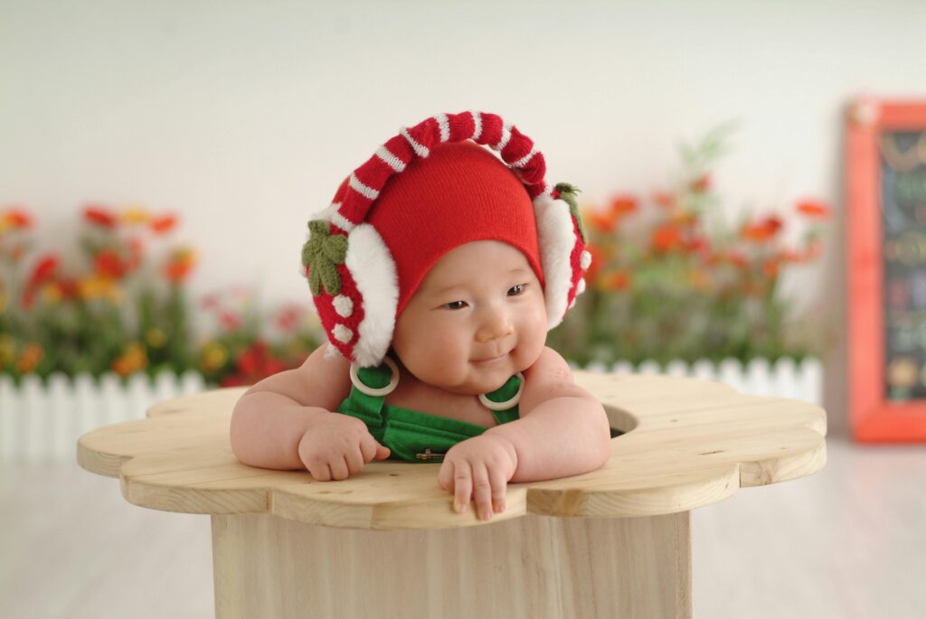 pexels-photo-25682033-25682033 Charming portrait of a baby wearing a cute red cap and earmuffs, exuding innocence and joy.