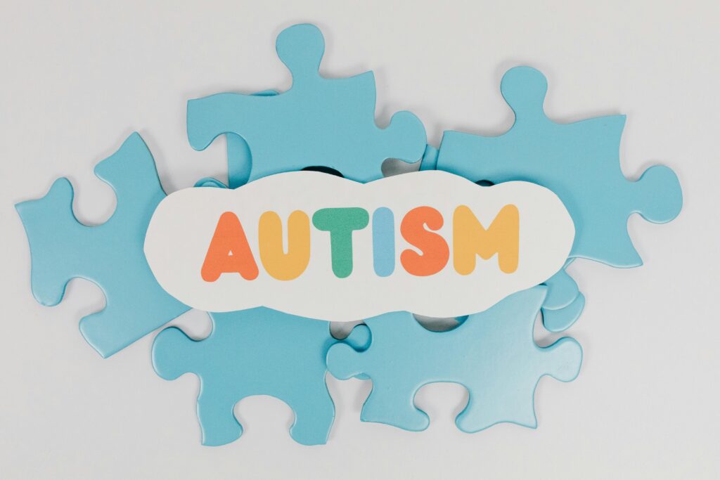pexels-photo-8385735-8385735-1 Colorful puzzle pieces with 'AUTISM' text symbolizing autism awareness.